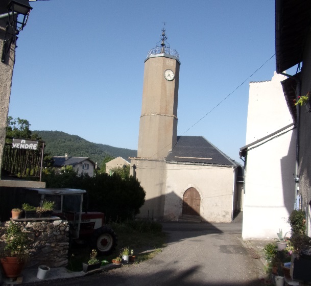 Le Bousquet, clocher de l'église face horloge et incription année de rénovation 1951
