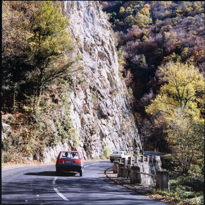Vues d'une voiture sur la route et d'un versant rocheux des gorges de l'Aude.